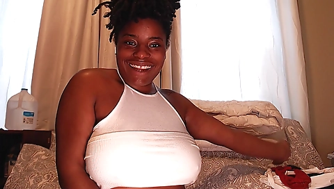Ebony teen is showing her body in a skirt on a couch