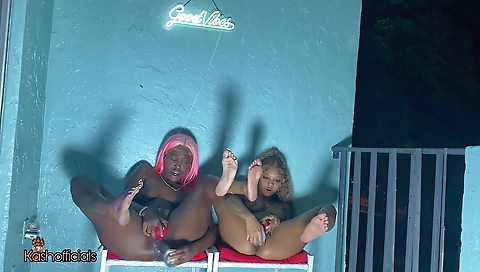 Ebony and brunette girl fuck in a balcony on camera