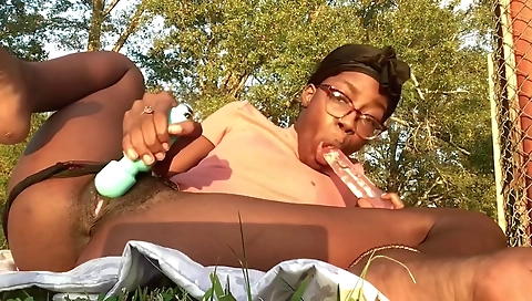 Ebony with sexy hairy pussy fucks herself outdoors